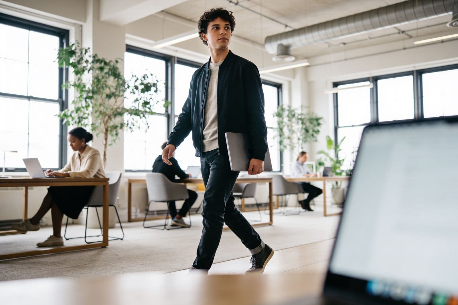 Un professionnel traverse un espace de travail lumineux et vivant